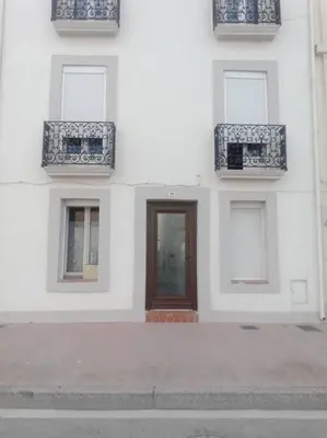 a building with blue and white windows and a door at Studio équipé 2 personnes, Port la Nouvelle centre in Port-la-Nouvelle