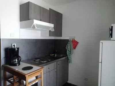 a kitchen with a stove and a white refrigerator at Studio équipé 2 personnes, Port la Nouvelle centre in Port-la-Nouvelle