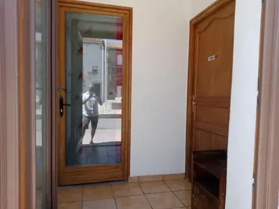 a person is standing in a hallway looking at a mirror at Studio équipé 2 personnes, Port la Nouvelle centre in Port-la-Nouvelle