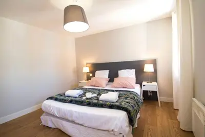 a bedroom with a large bed with two pillows at Le Saint Gimer - Vue sur la Cité Médiévale - Climatisation in Carcassonne