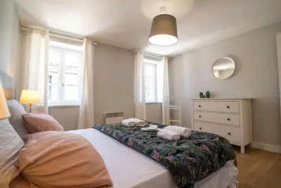a bedroom with a bed with two towels on it at Le Saint Gimer - Vue sur la Cité Médiévale - Climatisation in Carcassonne