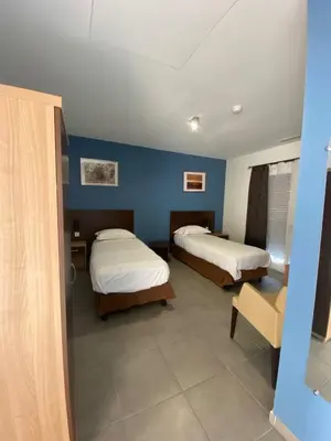 a room with two beds and a blue wall at Douce France in Cuxac-dʼAude