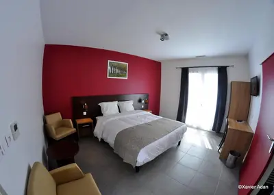 a bedroom with a bed and a red wall at Douce France in Cuxac-dʼAude