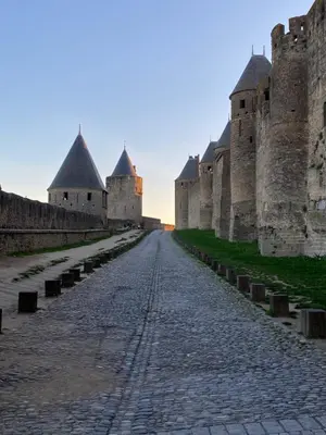 a cobblestone street in front of a castle at Vue sur Cité - SPA in Carcassonne