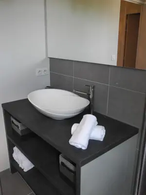 a bathroom with a sink and towels on a counter at Vue sur Cité - SPA in Carcassonne