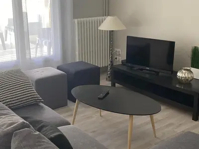 a living room with a couch and a flat screen tv at Vue sur Cité - SPA in Carcassonne