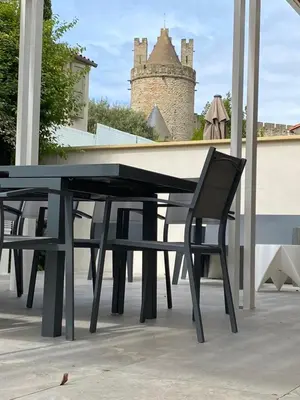 a black table and chair on a patio with a castle at Vue sur Cité - SPA in Carcassonne