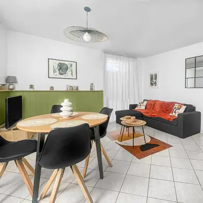 a living room with a table and a couch at Le Petit Paradis de Carcassonne in Carcassonne