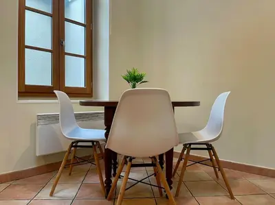 a table with three white chairs and a plant on it at La Traverse - au pied de la Cité Médiévale - Clim et terrasse in Carcassonne