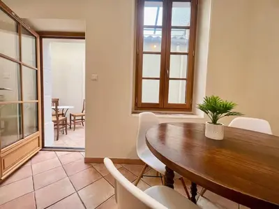 a dining room with a wooden table and chairs at La Traverse - au pied de la Cité Médiévale - Clim et terrasse in Carcassonne
