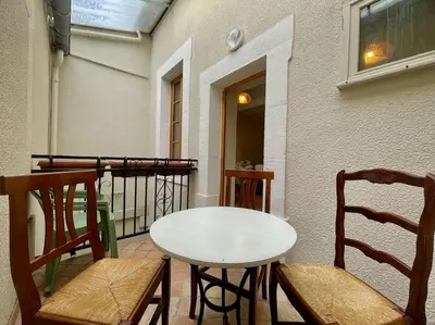 a table and chairs on the balcony of a building at La Traverse - au pied de la Cité Médiévale - Clim et terrasse in Carcassonne