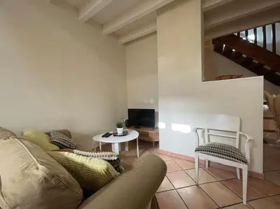 a living room with a couch and a table at La Traverse - au pied de la Cité Médiévale - Clim et terrasse in Carcassonne