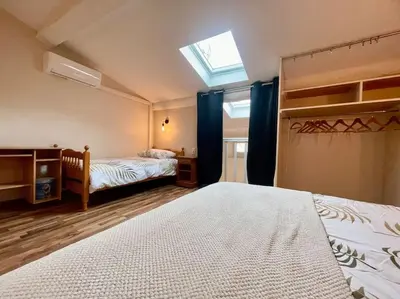 a bedroom with two beds and a skylight at La Traverse - au pied de la Cité Médiévale - Clim et terrasse in Carcassonne
