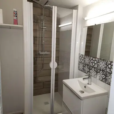 a white bathroom with a shower and a sink at Le Grand Studio in Castres