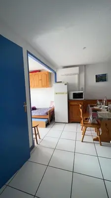 a kitchen with a refrigerator and a table and a table at La terrasse de Gruissan in Gruissan
