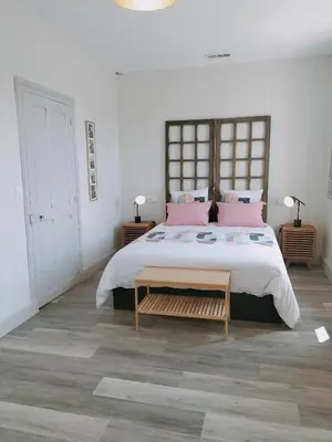 a bedroom with a large bed with pink pillows at L'école buissonnière in Laroque-dʼOlmes