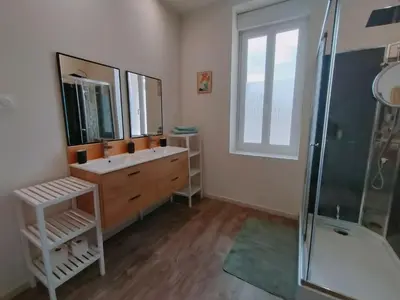 a bathroom with a sink and a glass shower at L'école buissonnière in Laroque-dʼOlmes