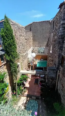 a patio with a table and chairs in a building at Les deux arches in Caunes-Minervois