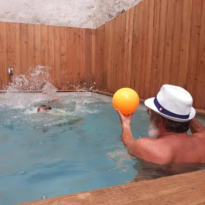 a man playing with a ball in a swimming pool at Les deux arches in Caunes-Minervois