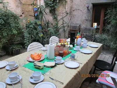 a wooden table with plates of food on it at Les deux arches in Caunes-Minervois