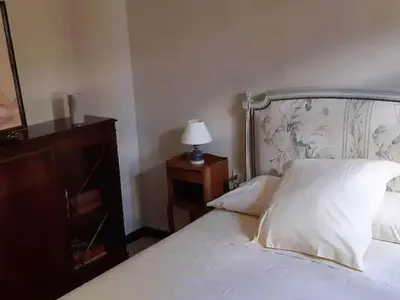a bedroom with a bed and a dresser with a lamp at Tranquil Villa, Nature s Embrace in Cazouls-lès-Béziers