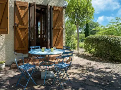 a table and chairs in front of a house at Tranquil Villa, Nature s Embrace in Cazouls-lès-Béziers