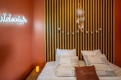 a bedroom with a bed with white pillows on it at Le Lovely Gruissanais - Balneo & Sauna in Gruissan