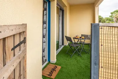 a patio with a table and chairs on the side of a house at Le Lovely Gruissanais - Balneo & Sauna in Gruissan