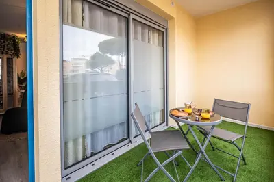 a balcony with a table and two chairs and a window at Le Lovely Gruissanais - Balneo & Sauna in Gruissan
