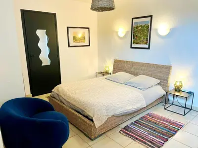 a bedroom with a bed and a blue chair at Grand et bel appartement classé 3 étoiles in Lavelanet