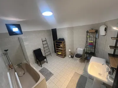 a bathroom with a bath tub and a sink at Grand et bel appartement classé 3 étoiles in Lavelanet
