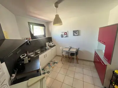 a small kitchen with a sink and a table at Grand et bel appartement classé 3 étoiles in Lavelanet