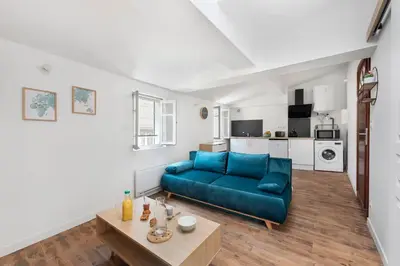 a living room with a blue couch and a table at Les studios Jean Bringer - Carcassonne centre-ville in Carcassonne