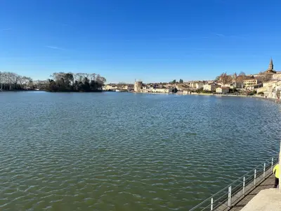 a large body of water with buildings in the background at Le bassin - Vue canal du midi avec climatisation et garage in Castelnaudary