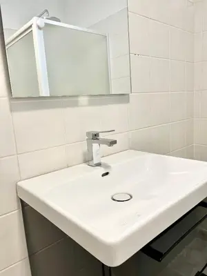 a bathroom with a white sink and a mirror at Le bassin - Vue canal du midi avec climatisation et garage in Castelnaudary