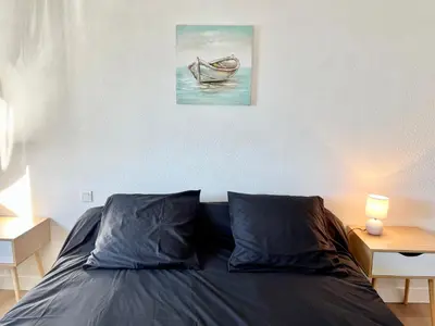 a bedroom with a bed with a painting on the wall at Le bassin - Vue canal du midi avec climatisation et garage in Castelnaudary
