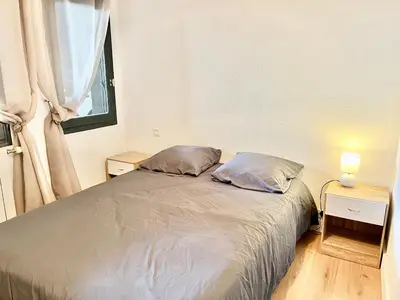 a bedroom with a bed with two pillows and a window at Le bassin - Vue canal du midi avec climatisation et garage in Castelnaudary
