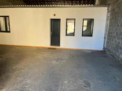 an empty room with a black door and three windows at Le bassin - Vue canal du midi avec climatisation et garage in Castelnaudary