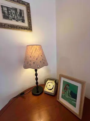 a lamp on a table with a picture and a clock at The hat factory in Espéraza