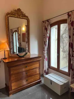 a room with a dresser with a mirror and a window at The hat factory in Espéraza