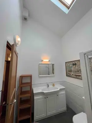 a white bathroom with a sink and a mirror at The hat factory in Espéraza