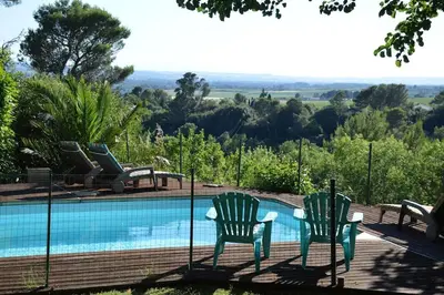 two chairs sitting next to a swimming pool at Chalet, quiet, with view and pool (at summertime) in Ventenac-Cabardès