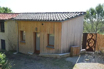 a small wooden house with windows and a fence at Chalet, quiet, with view and pool (at summertime) in Ventenac-Cabardès
