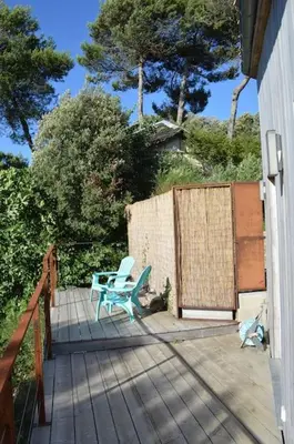 a patio with a blue chair and a table at Chalet, calme, absolu, superbe vue, et piscine (en été) in Ventenac-Cabardès