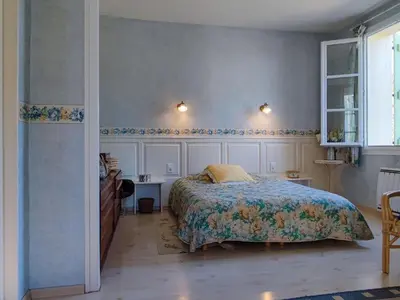 a bedroom with a bed and a desk and a window at Spacious holiday home with private pool and park in Puisserguier