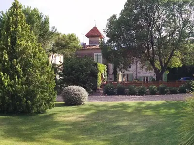 a large house with a yard with trees and grass at Spacious holiday home with private pool and park in Puisserguier