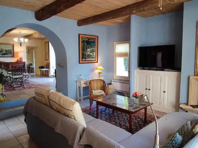 a living room with a couch and a table at Spacious holiday home with private pool and park in Puisserguier