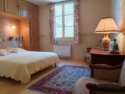 a bedroom with a bed and a lamp on a desk at Spacious holiday home with private pool and park in Puisserguier