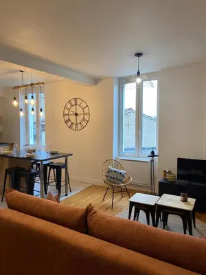 a living room with a couch and a dining room at Chez Julie in Castres