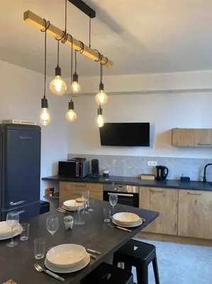 a kitchen with a table with plates and wine glasses at Chez Julie in Castres